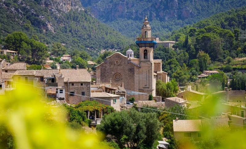 Church of Església de Sant Bartolomeu standing in a lush valley in Valldemossa, Mallorca.