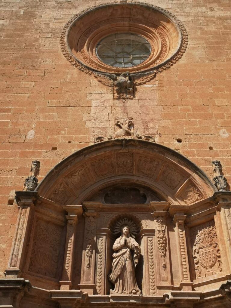 Baroque portal in the facade of Sant Bonaventura church in Llucmajor, Mallorca, with a rosette above it.
