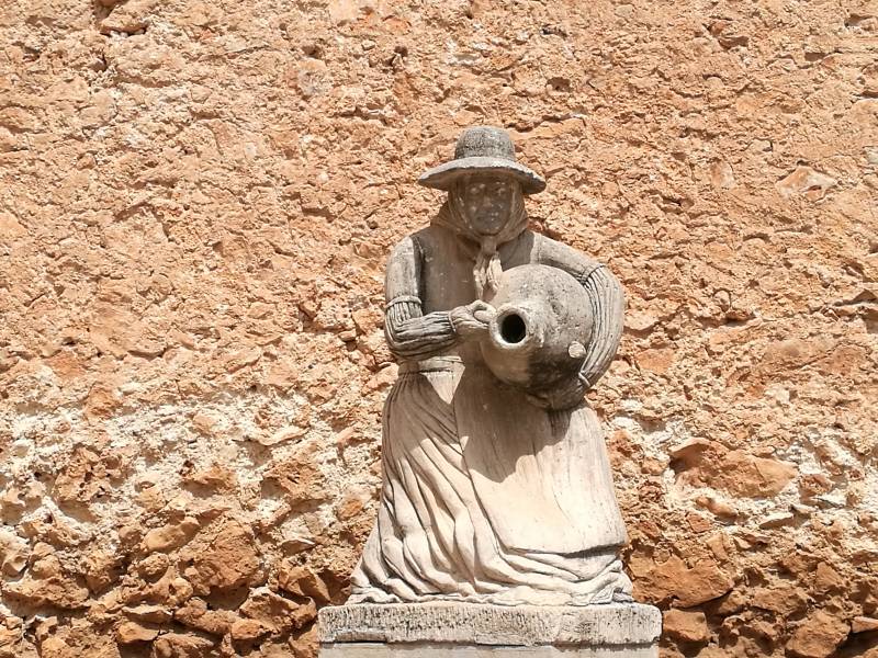 Sculpture of a Mallorcan farm woman standing in front of the convent of Santa Anna in Muro village, Mallorca.