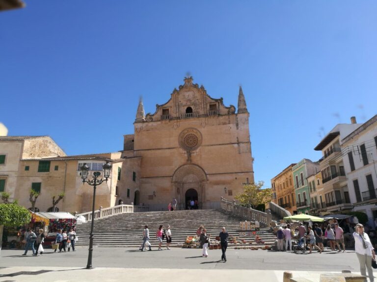 Guide showing tourists around in Felanitx town in front of the parish church, Mallorca island, Spain.