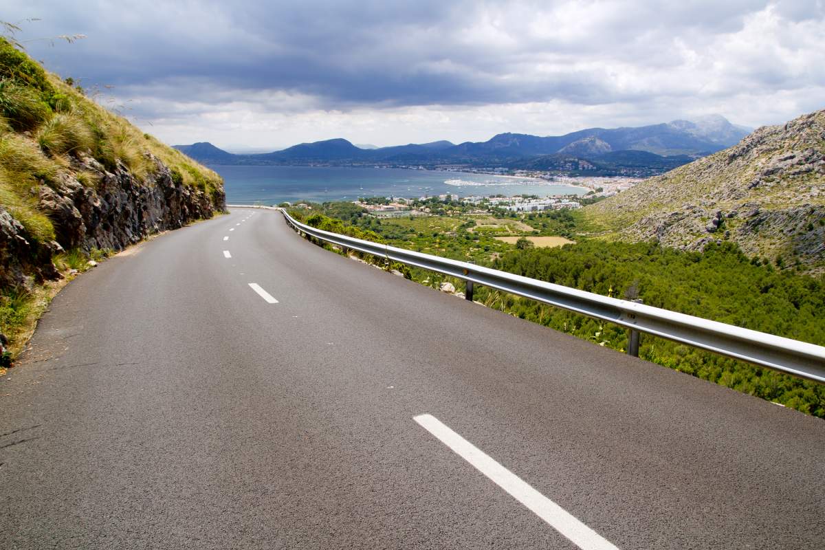 Driving car from driver's perspective down a road in the Tramuntana mountains towards Port de Pollenca, Mallorca.