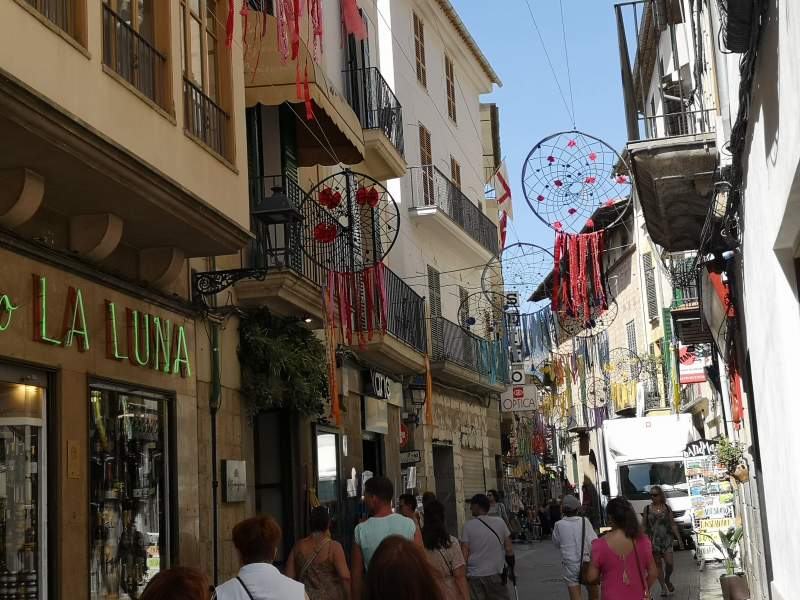 People in a shopping street in Sóller town, Mallorca island.