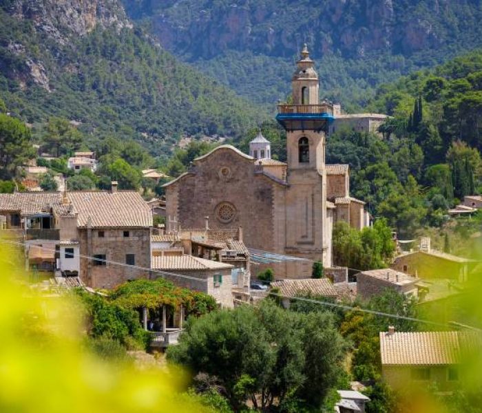Church of Església de Sant Bartolomeu standing in a lush valley in Valldemossa, Mallorca.