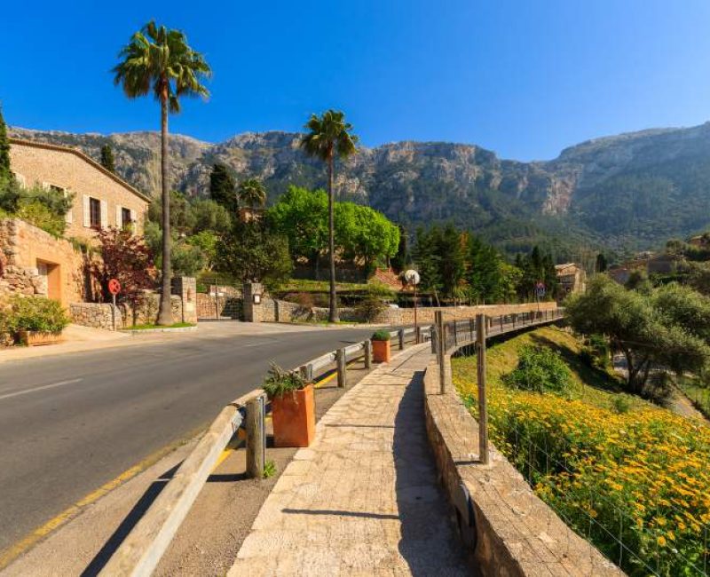 Picturesque village of Deia, Mallorca, Spain, nestled between the green lush mountains in a valley.