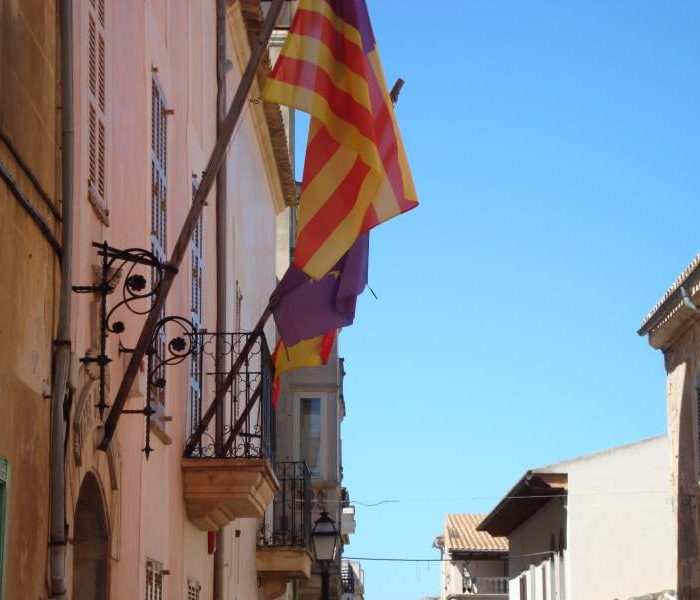 Flags hanging from the facade of the Casa de la Vila citizens house in Petra villa, Mallorca.
