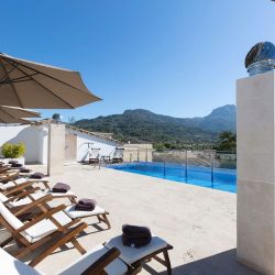 Rooftop swimming pool with panoramic views of the lush Tramuntana mountains at Gran Hotel Sóller, Mallorca.