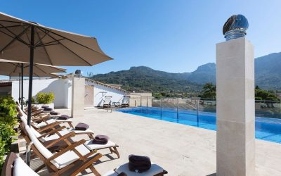 Rooftop swimming pool with panoramic views of the lush Tramuntana mountains at Gran Hotel Sóller, Mallorca.