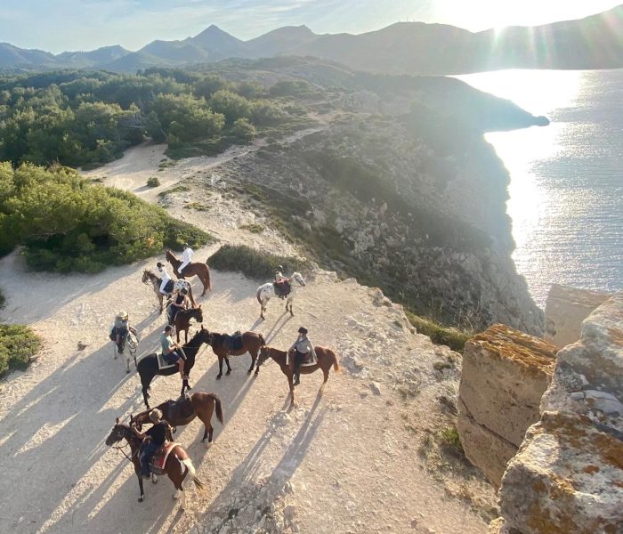 Group from Naturacavall doing horseback riding on Formentor peninsula, Mallorca, at sunset.
